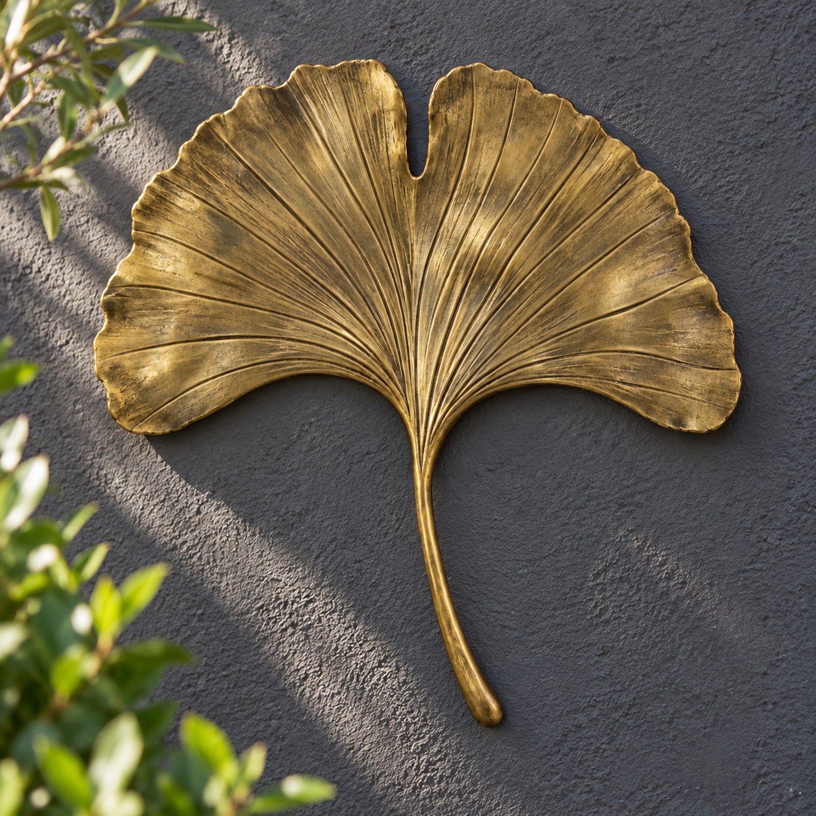 Antique-brass-finish ginkgo leaf on a charcoal wall